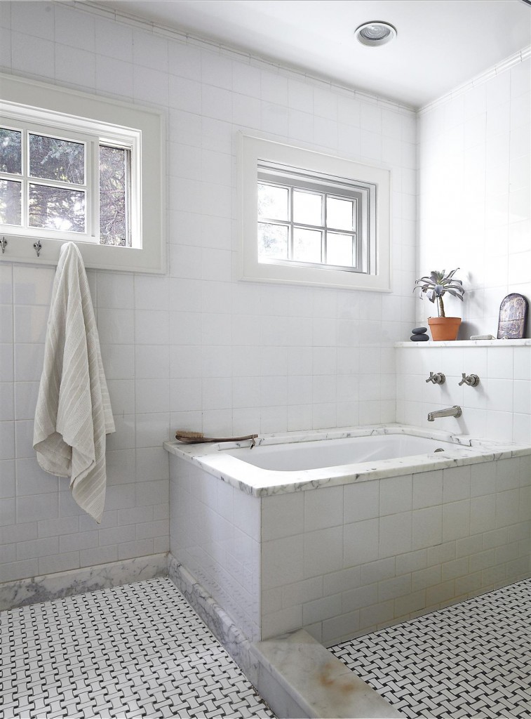 The tub and fittings in the master bath are by Waterworks, and the floor tiles are from Ann Sacks. 