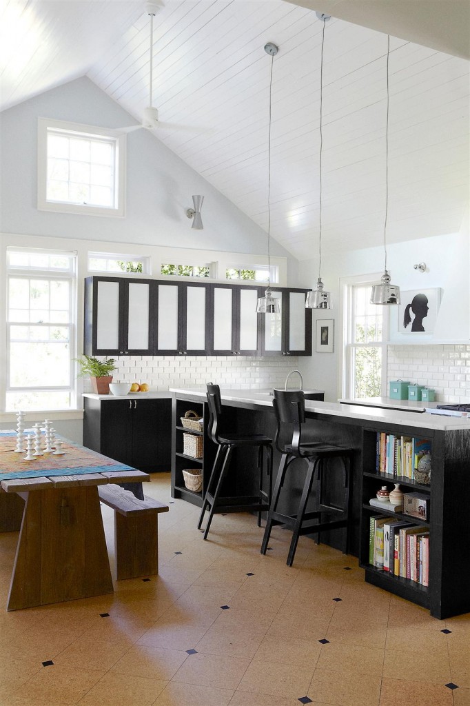 endant lights by Produzione Privata hang above the marble-top kitchen counter, the bar chairs are by Thonet, and the table is custom made, as are the milk glass–lined cabinets; the backsplash tiles are by Waterworks.