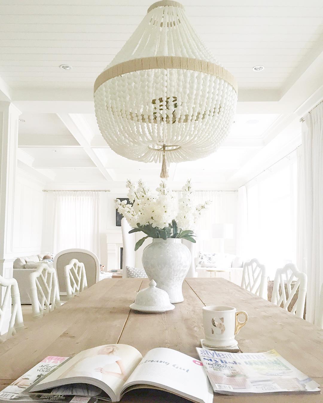 White painted wood paneled ceiling, white walls, blonde wood raw table.