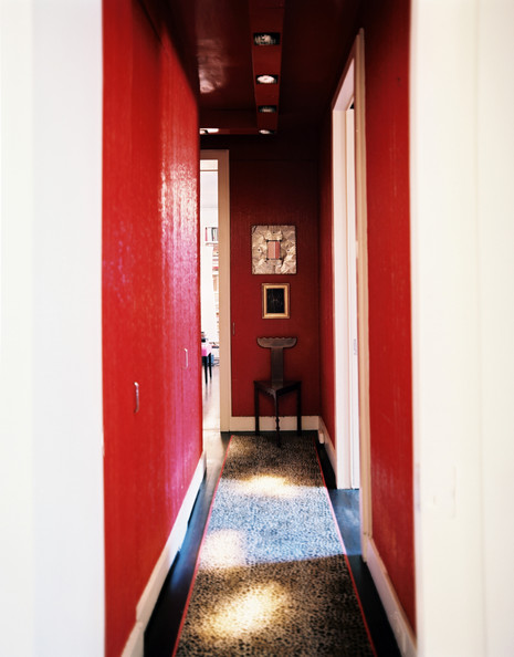 Red walls and a leopard-print carpet runner in a long hallway Details: Red Eclectic-Modern Hallway