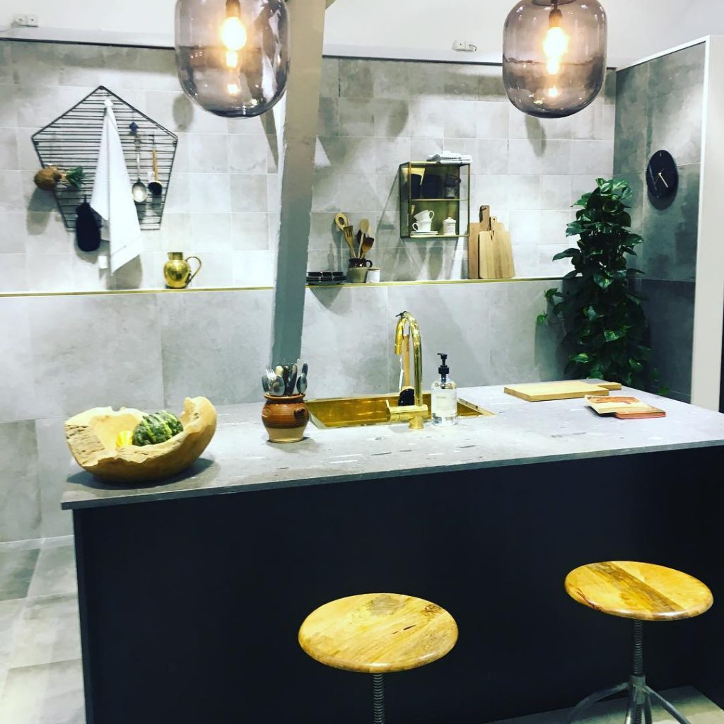 Kitchen with concrete tiles on the walls and splashback