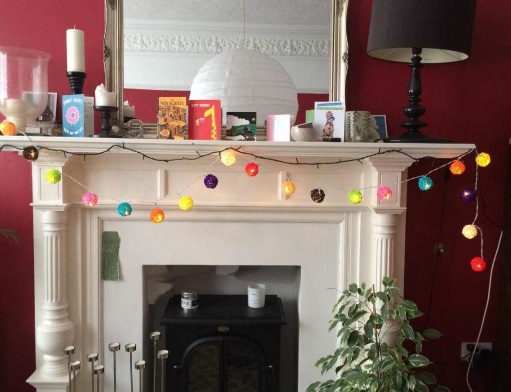 Fireplace painted in white and walls in Farrow & Ball's Rectory Red