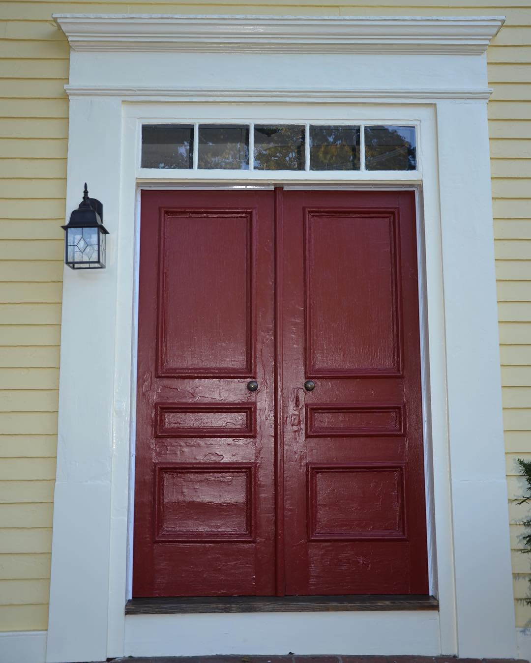 Red painted door, white trim and yellow walls exterior