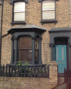 Front door in Farrow & Ball Vardo and window frames and awnings in Farrow & Ball Railings