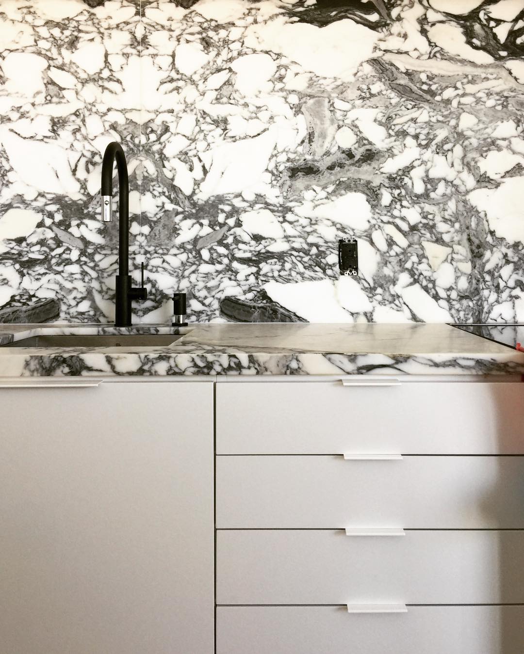 Black and White Marble Kitchen Color Scheme. Timber herringbone flooring kitchen, black taps and hardware.