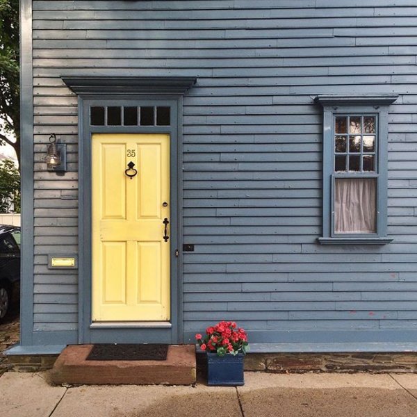 Blue exterior paint color in Sherwin Williams' Bracing Blue and yellow door in Sunny Veranda. Exterior paint color scheme in blue and yellow.