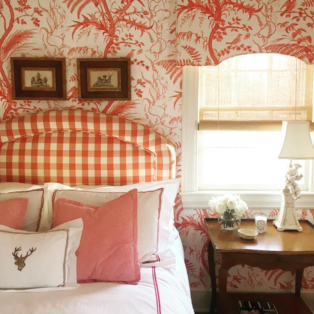 Red bedroom color scheme with red wallpaper and gingham headboard.