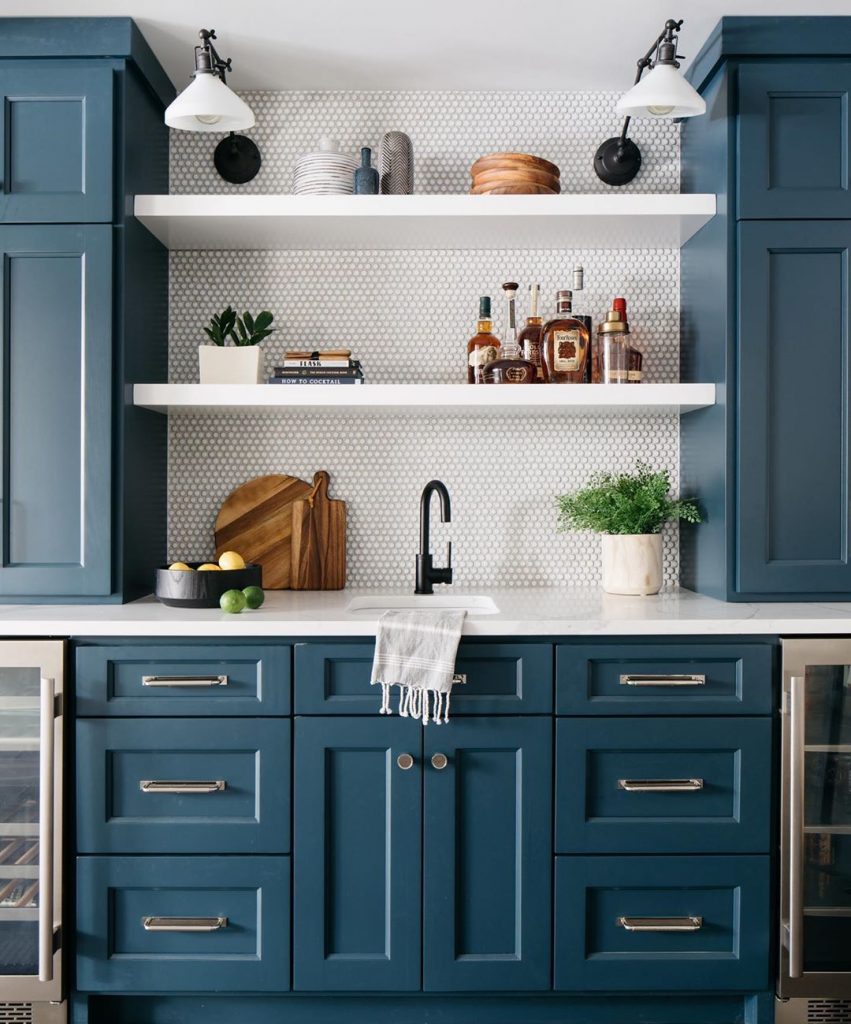 Kitchen with navy blue kitchen cabonets and penny rounds splashback