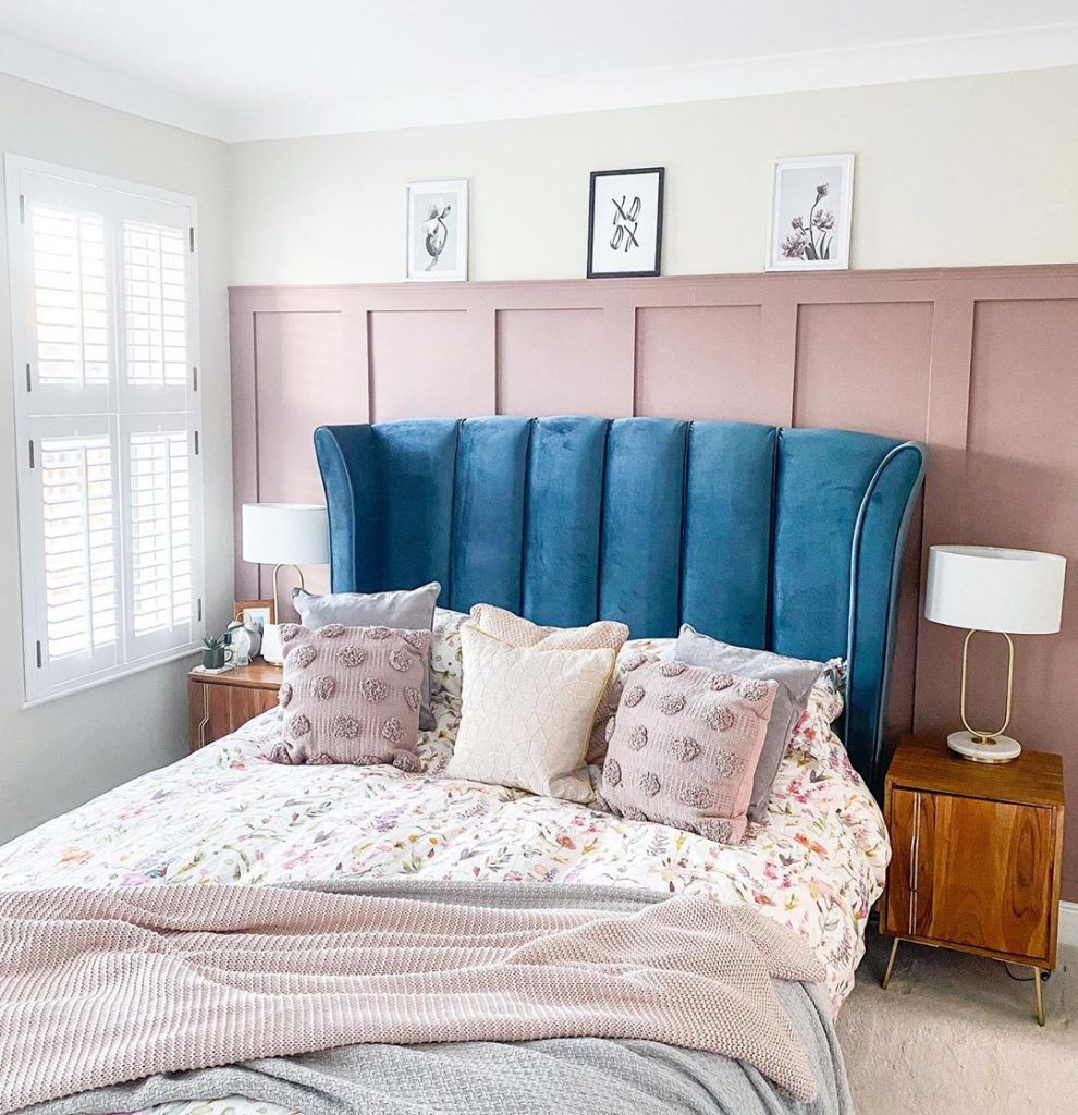 Farrow & Ball Sulking Room Pink feature wall master bedroom. Blue velvet headboard. Romantic bedroom design interior with a blue and mauve pink color scheme