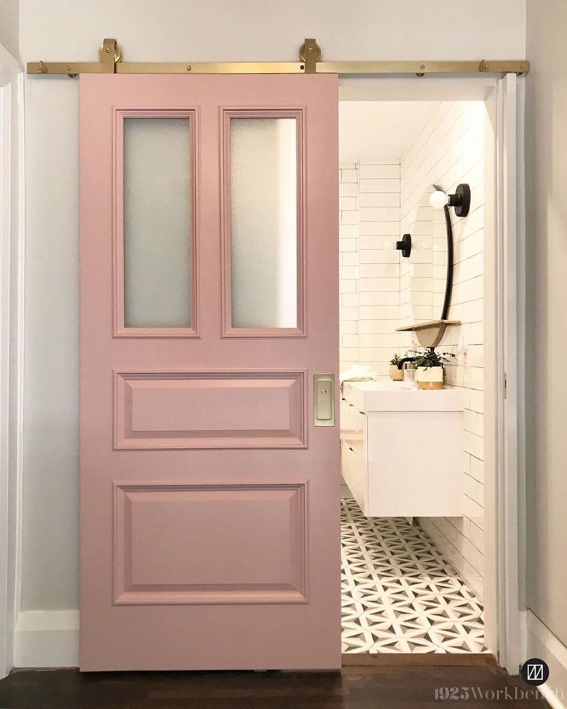 Pink painted barn door bathroom