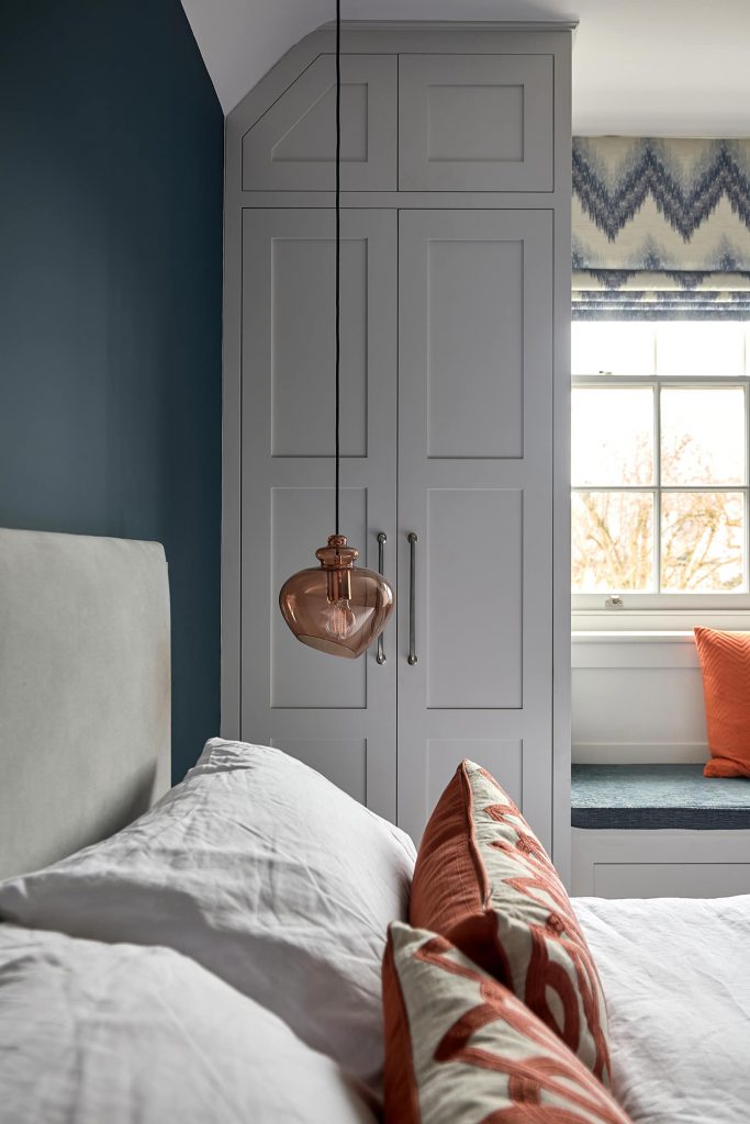 Bedroom Walls Painted in Farrow and Ball Ammonite. Blue and orange color scheme interior