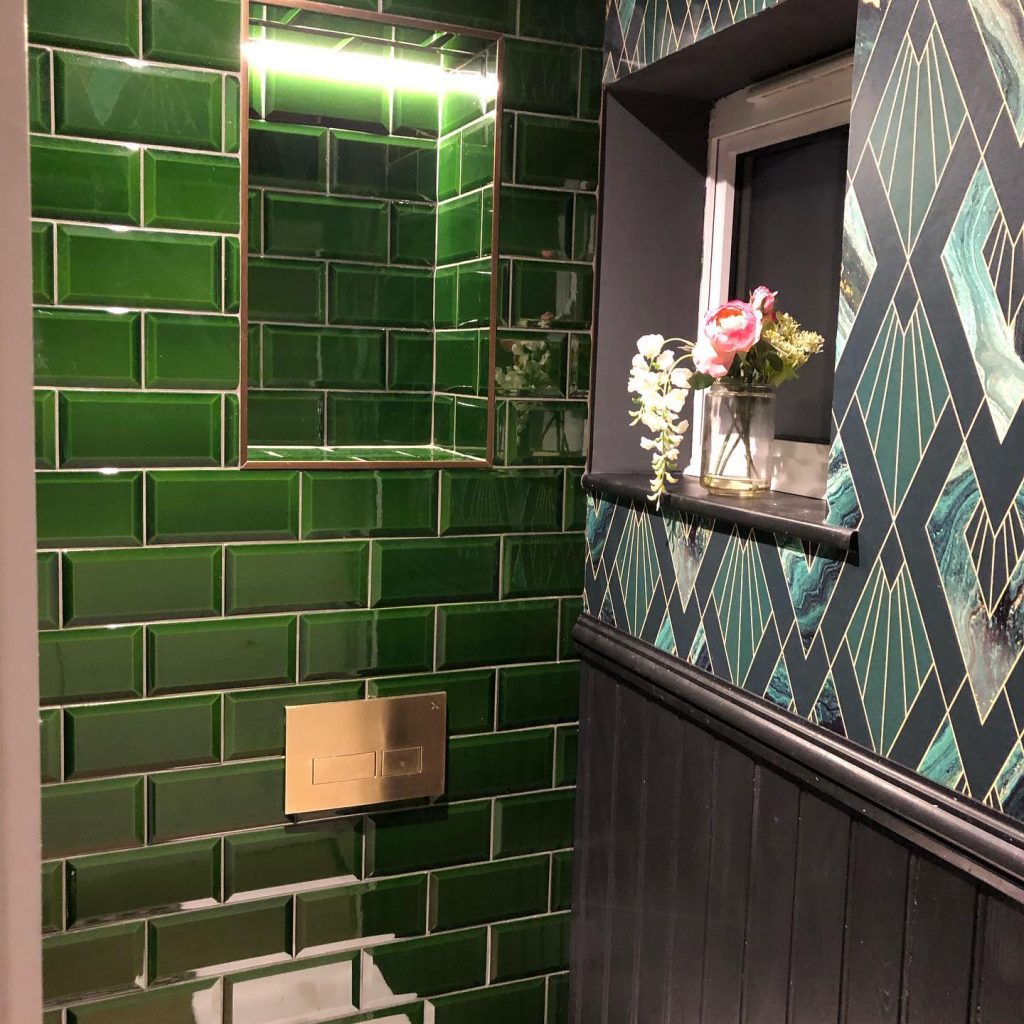 Green subway tiles and art deco wallpaper bathroom design