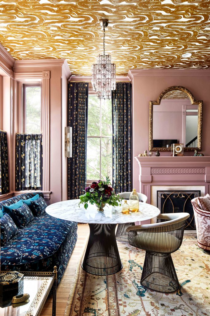 pink walls and gold pattern wallpaper on the ceiling