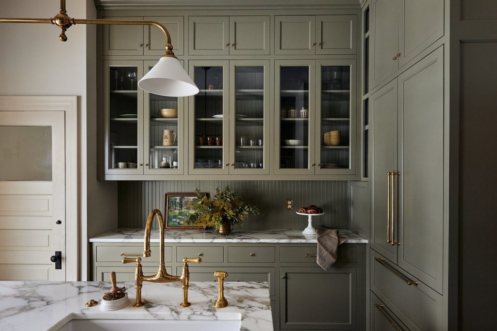 sage green kitchen with brass hardware