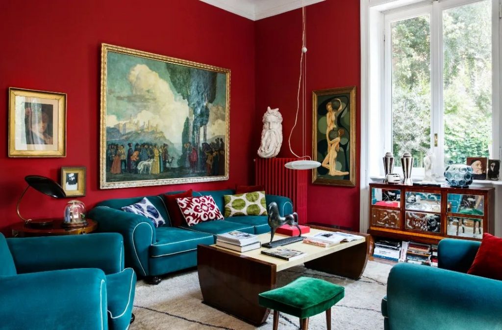 bold red walls interior with teal green sofa