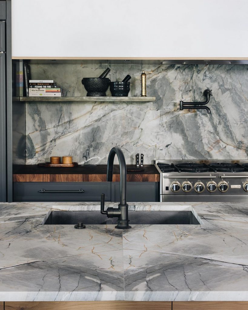 green kitchen with quartz countertops and backsplash