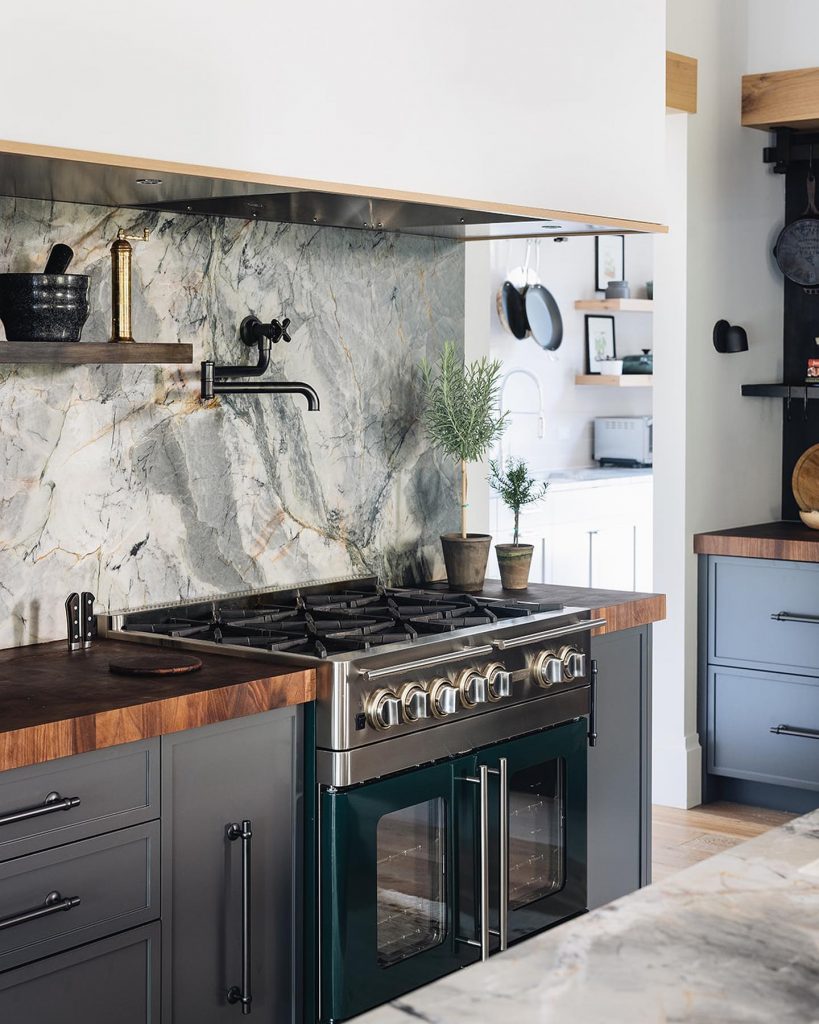 green kitchen with quartz countertops and backsplash